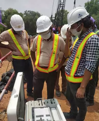 An image of construction workers wearing safety hats and working