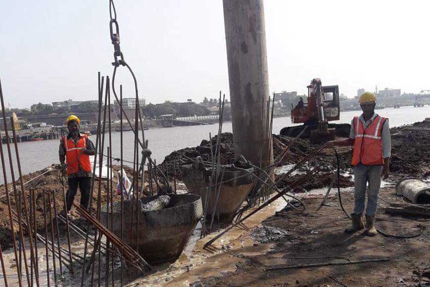 two workers standing next to an in-progress diaphragm wall construction project